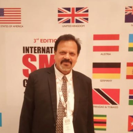 Managing Director smiling in a professional office environment with digital screens in the background